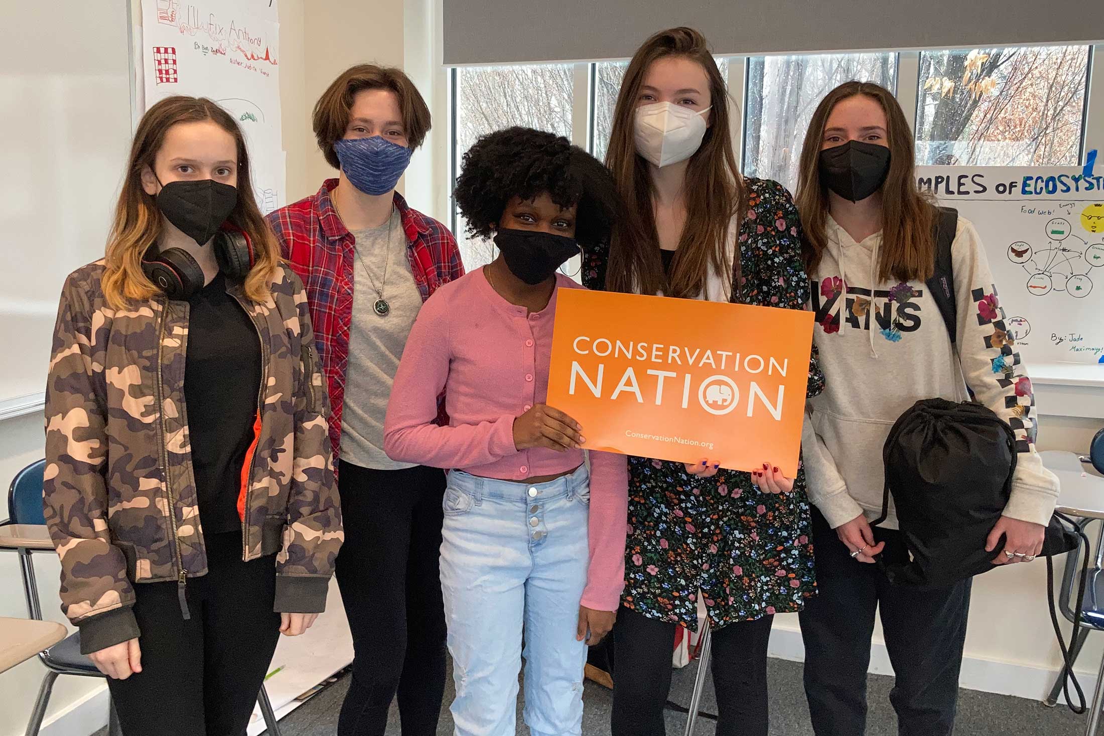 a group of Field School students holding a Conservation Nation sign