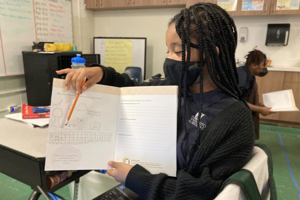 Washington School for Girls student pointing to something in a journal