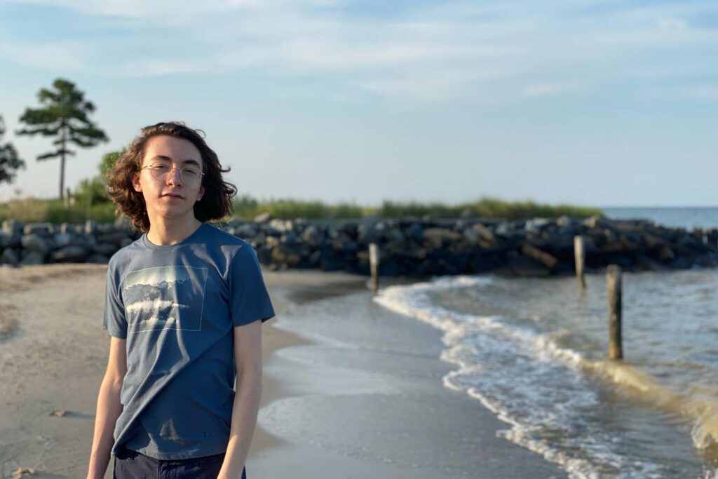 Conservation Nation Youth Advisor Harry standing on a sandy shore