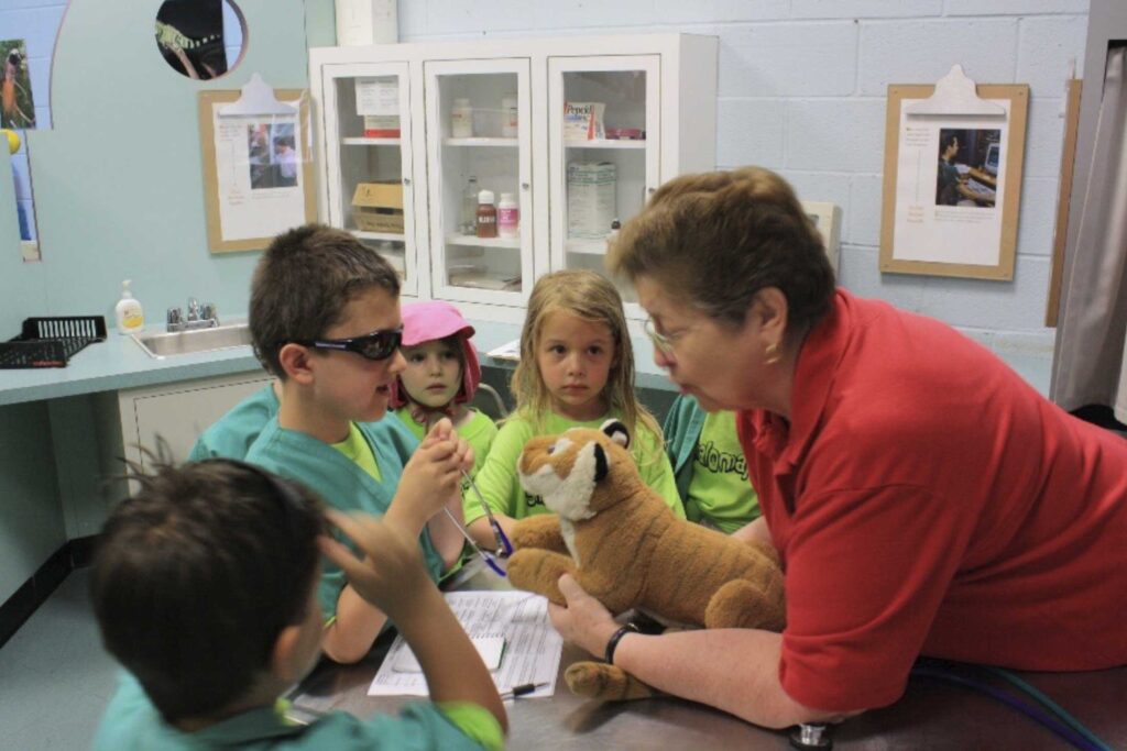 a fonz educator interacting with children in a veterinarian office simulation