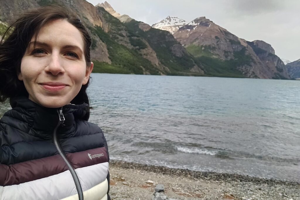 Conservation Nation grantee Giorgia Auteri on a rocky shoreline with mountains in the background