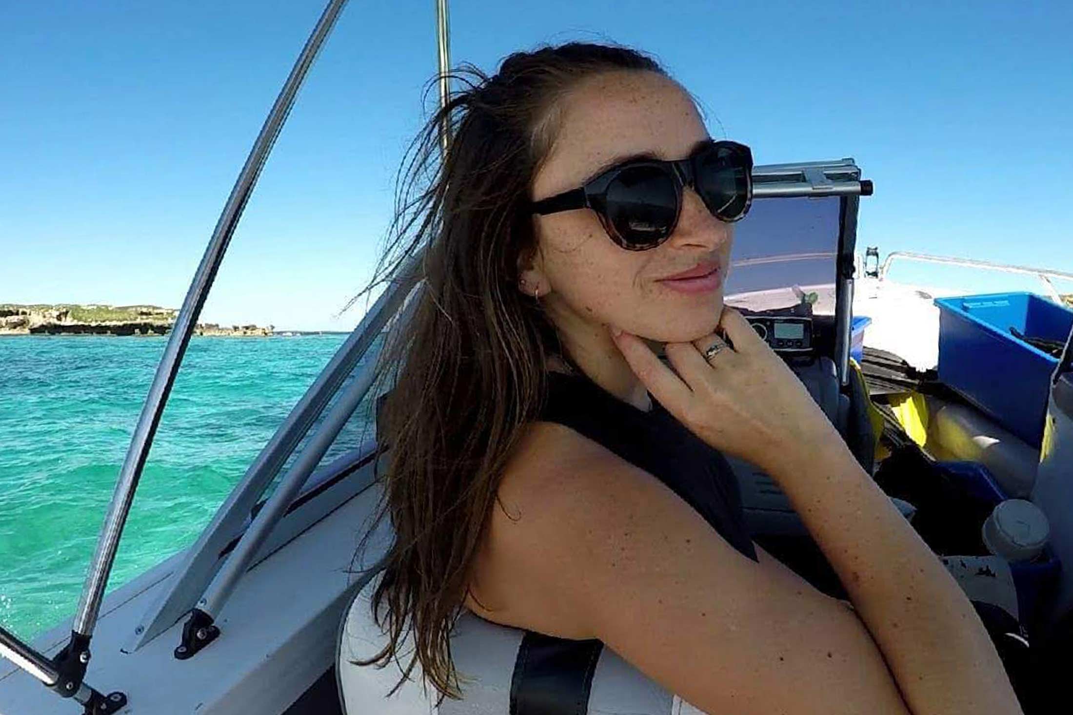 woman wearing sunglasses on a boat cruising in blue water