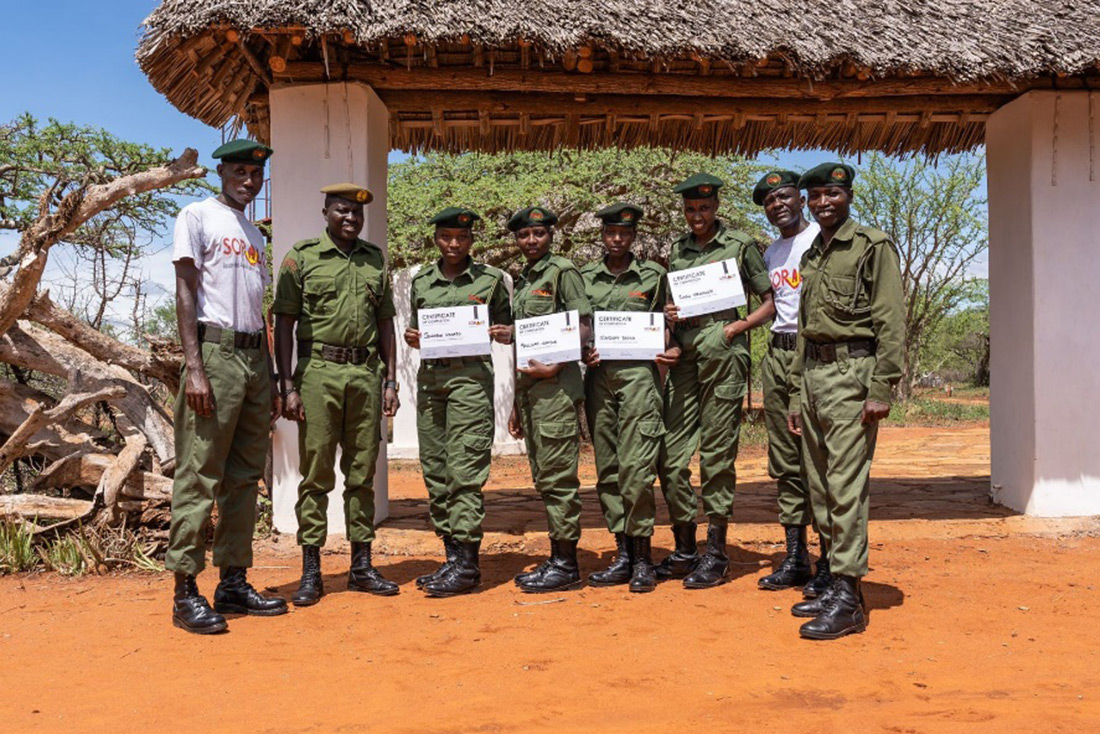 eight uniformed park rangers with four of them holding up certificates