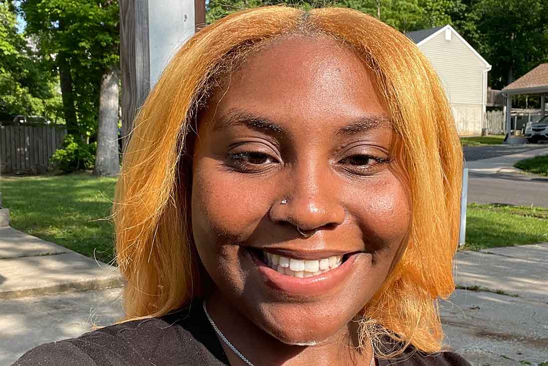 a Black woman takes a selfie while smiling