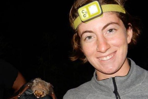 Conservation Nation grantee Morgan Hughes wearing a headlamp and holding a bat